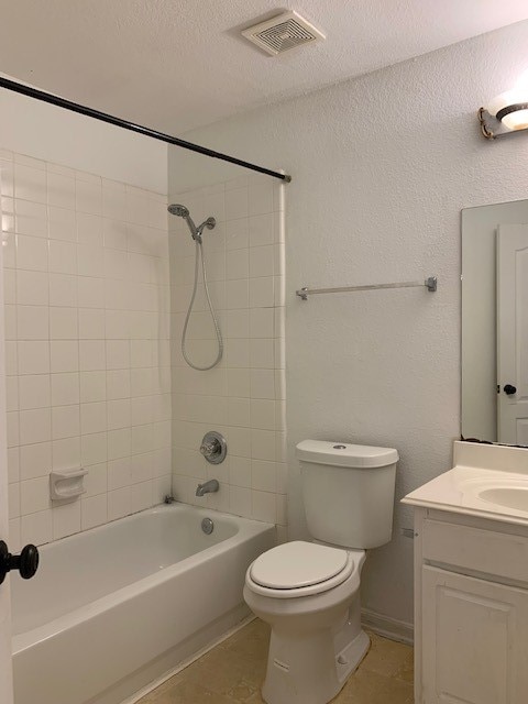 full bathroom with vanity, toilet, tiled shower / bath, and tile patterned floors