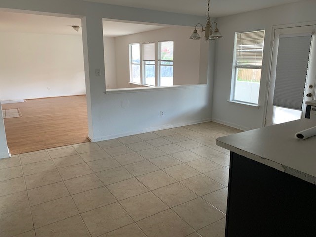 unfurnished dining area featuring light hardwood / wood-style floors and a notable chandelier