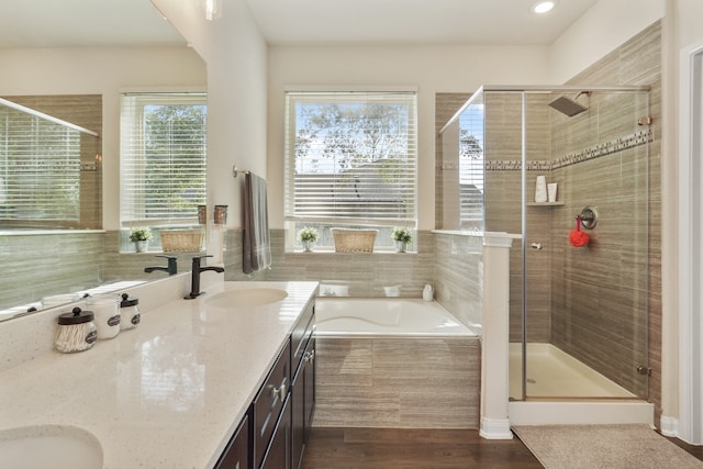 bathroom with hardwood / wood-style flooring, vanity, and separate shower and tub