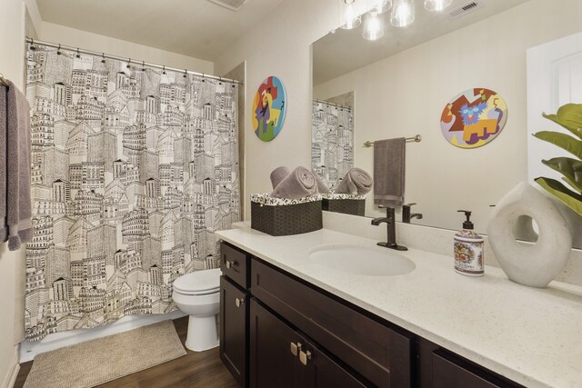 bathroom with wood-type flooring, walk in shower, vanity, and toilet