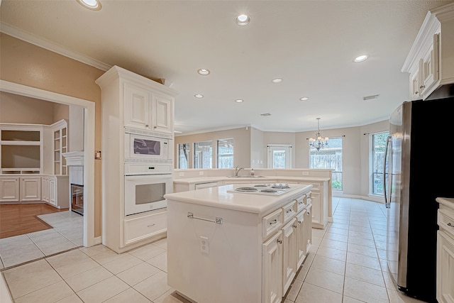 kitchen featuring plenty of natural light, a kitchen island, white appliances, and ornamental molding