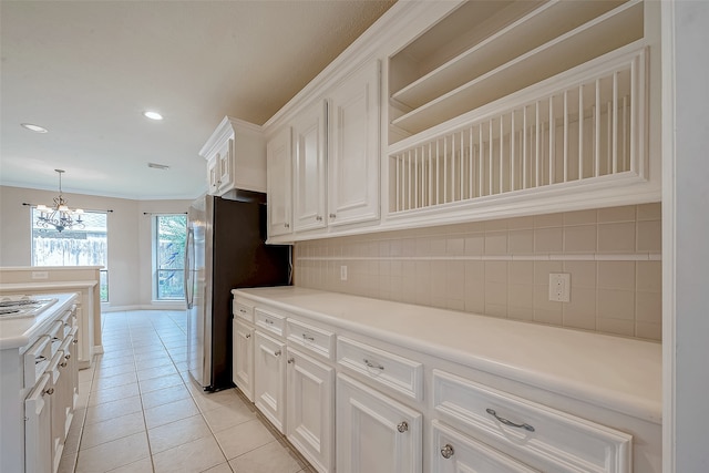 kitchen with hanging light fixtures, light tile patterned floors, an inviting chandelier, decorative backsplash, and white cabinets