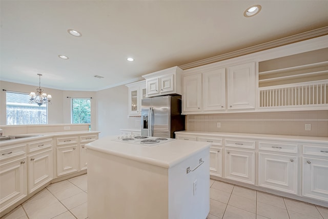 kitchen with stainless steel fridge, crown molding, a chandelier, white electric stovetop, and a kitchen island