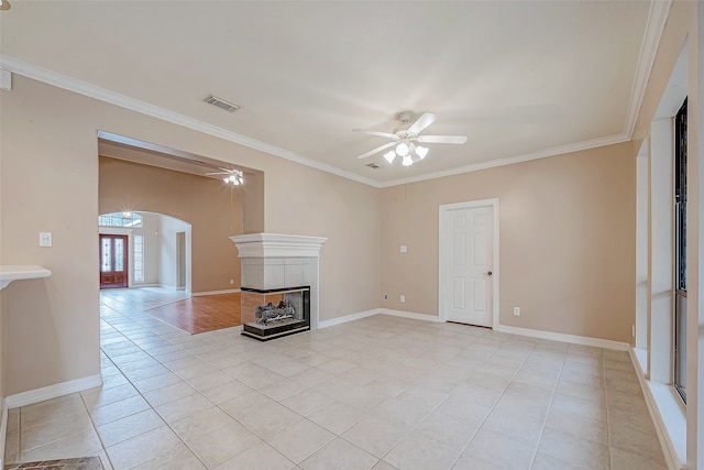 unfurnished living room featuring ceiling fan, a fireplace, light tile patterned flooring, and ornamental molding