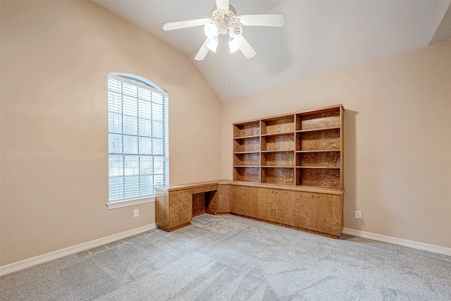 unfurnished office with ceiling fan, lofted ceiling, light carpet, and a wealth of natural light