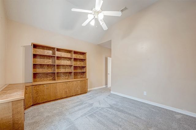 interior space featuring ceiling fan, light colored carpet, and vaulted ceiling