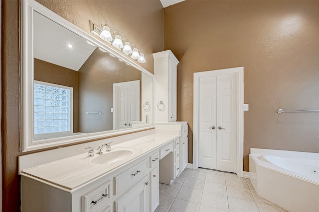 bathroom featuring tile patterned flooring, vanity, vaulted ceiling, and a bathtub