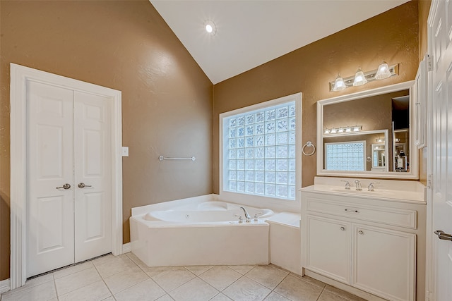 bathroom with a washtub, vanity, tile patterned floors, and lofted ceiling