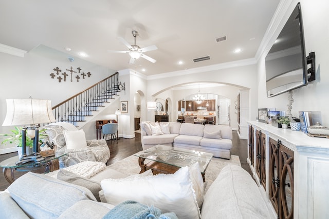 living room featuring ceiling fan with notable chandelier, light wood-type flooring, and ornamental molding