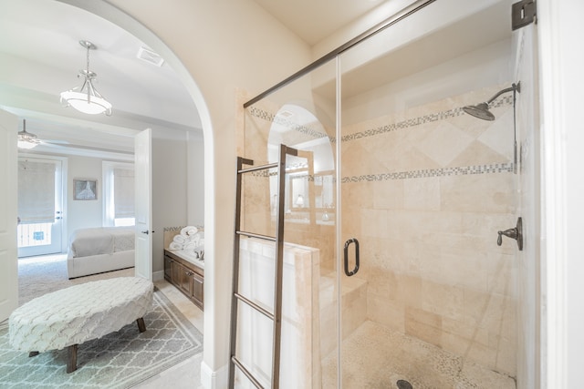 bathroom with ceiling fan and an enclosed shower