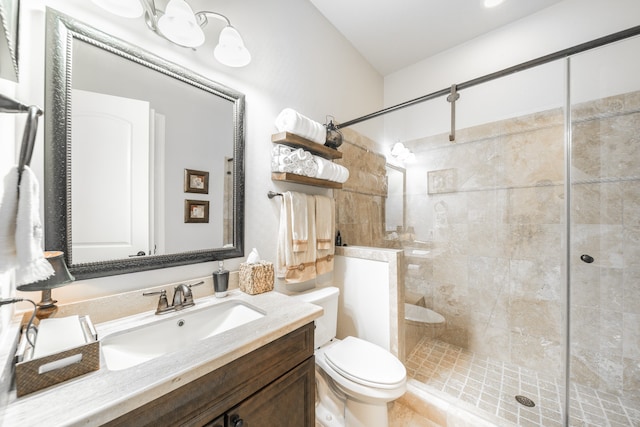 bathroom with tiled shower, vanity, and toilet