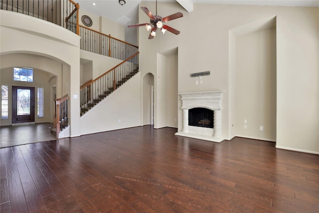 19815 Stanton Lake Dr, Cypress, TX 77433 - unfurnished living room featuring high vaulted ceiling, arched walkways, stairway, ceiling fan, and hardwood / wood-style flooring