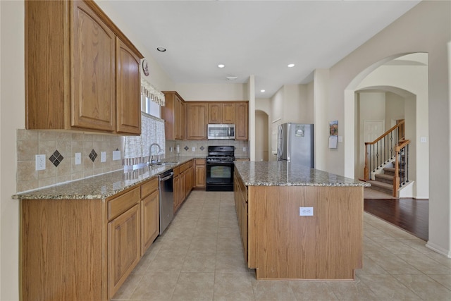 19815 Stanton Lake Dr, Cypress, TX 77433 - kitchen with stainless steel appliances, a sink, stone countertops, a center island, and decorative backsplash