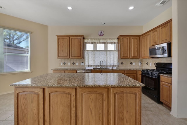 19815 Stanton Lake Dr, Cypress, TX 77433 - kitchen featuring stainless steel appliances, a sink, light tile patterned floors, a center island, and recessed lighting