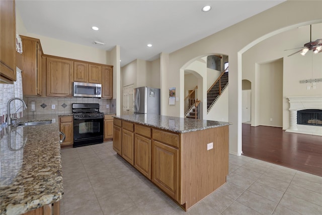 19815 Stanton Lake Dr, Cypress, TX 77433 - kitchen with appliances with stainless steel finishes, a sink, light tile patterned flooring, dark stone counters, and a ceiling fan