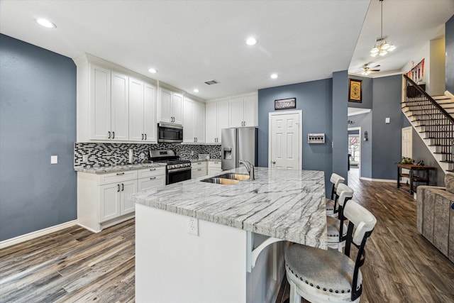 kitchen with sink, white cabinetry, appliances with stainless steel finishes, and hanging light fixtures