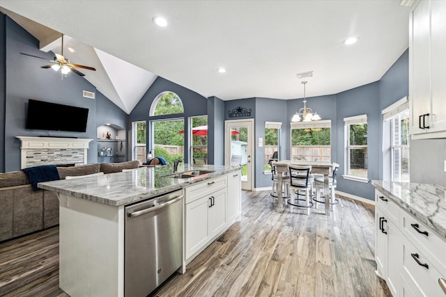 kitchen featuring white cabinets, dishwasher, light stone counters, and hardwood / wood-style flooring