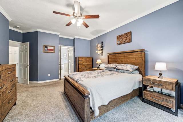 bedroom featuring ceiling fan, ensuite bathroom, crown molding, and light colored carpet