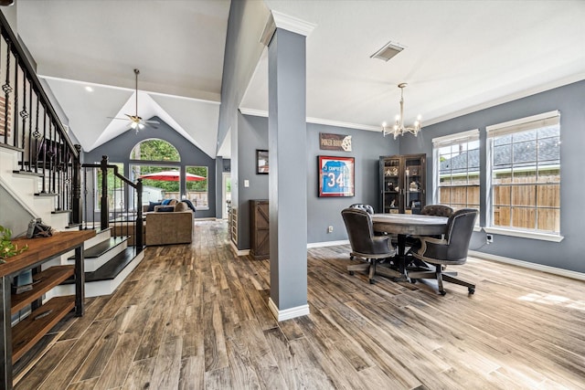 dining area featuring lofted ceiling, a wealth of natural light, ceiling fan with notable chandelier, and hardwood / wood-style floors