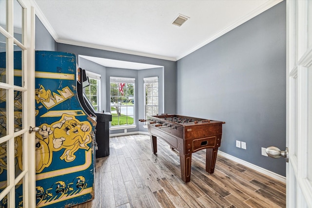 game room with hardwood / wood-style flooring and ornamental molding