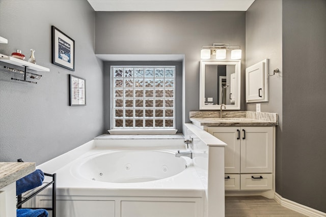 bathroom with a washtub and vanity