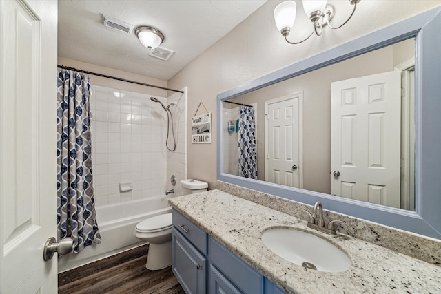 full bathroom with toilet, hardwood / wood-style floors, shower / bath combo with shower curtain, a textured ceiling, and vanity