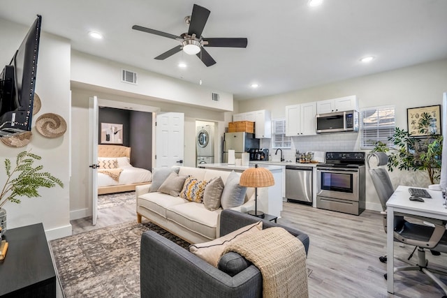 5 Estelle St Unit 1, Houston, TX 77003 - living room with stacked washer and clothes dryer, a ceiling fan, baseboards, light wood finished floors, and recessed lighting