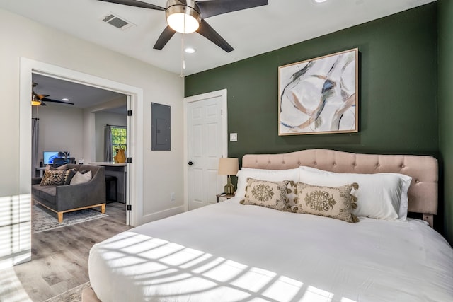 bedroom featuring electric panel, ceiling fan, and light hardwood / wood-style floors