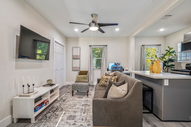 living room with ceiling fan and light hardwood / wood-style floors