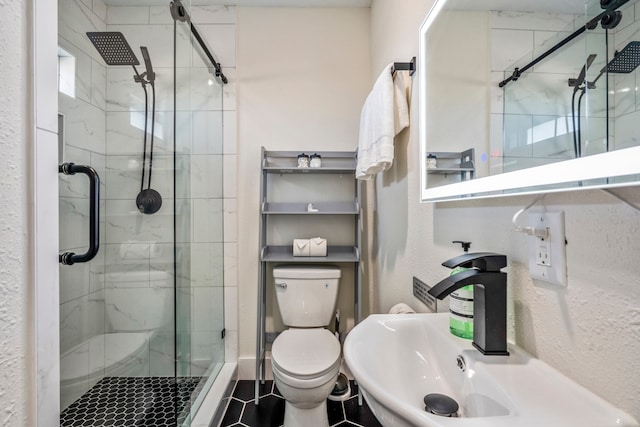 bathroom with sink, tile patterned flooring, a shower with shower door, and toilet