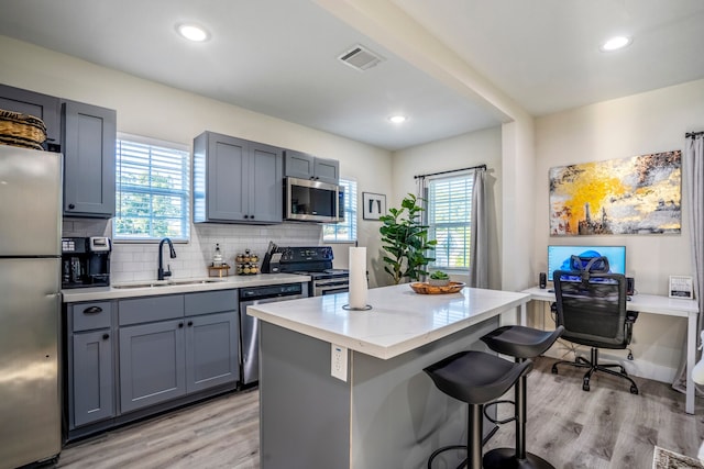 kitchen featuring light hardwood / wood-style flooring, sink, appliances with stainless steel finishes, and a center island