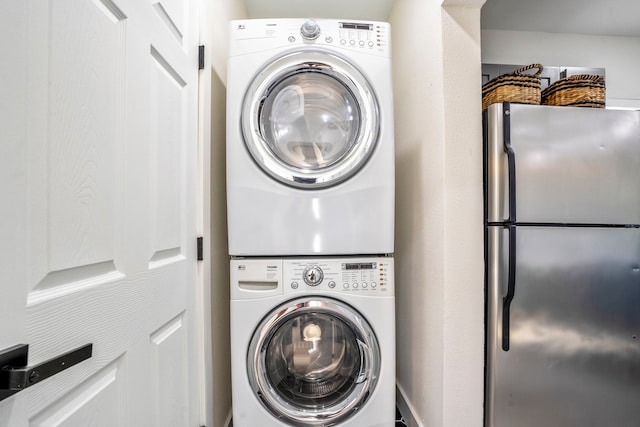 clothes washing area featuring stacked washing maching and dryer