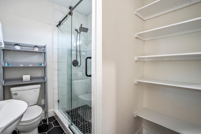 bathroom with tile patterned flooring, a shower with shower door, and toilet