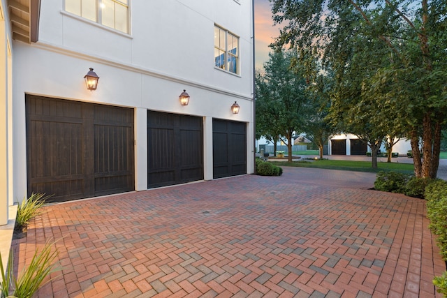 view of garage at dusk