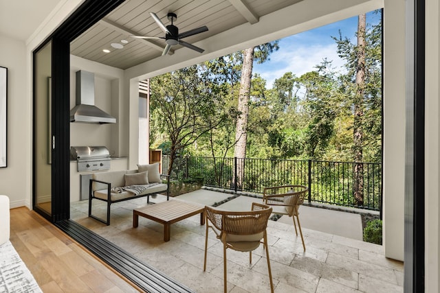 sunroom / solarium with ceiling fan, beamed ceiling, and wood ceiling