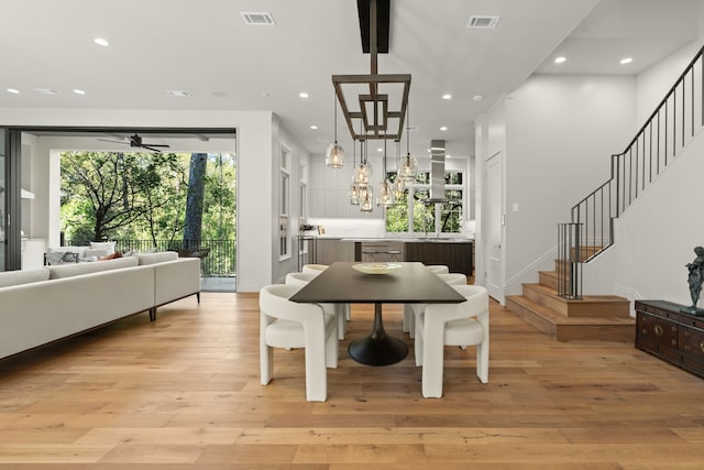 dining room featuring beamed ceiling, light wood-type flooring, and ceiling fan