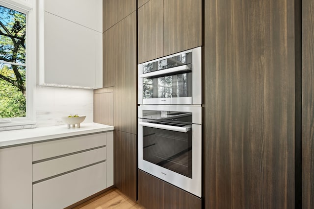 kitchen with plenty of natural light, white cabinets, and light wood-type flooring