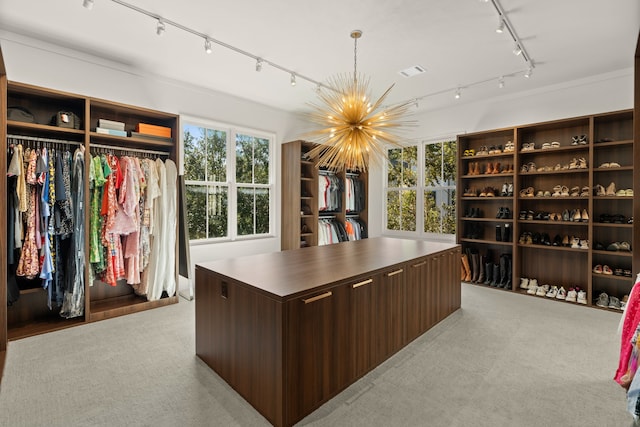 walk in closet with light carpet and a chandelier