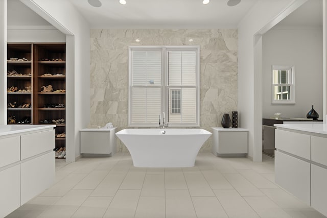 bathroom with tile patterned floors, a bathtub, vanity, and tile walls