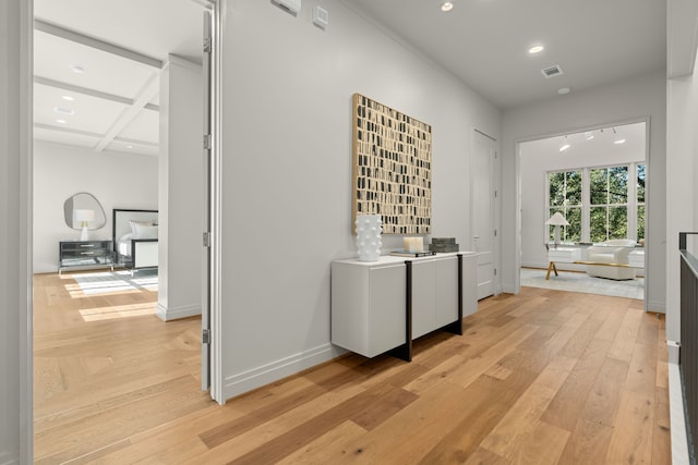 hall featuring beam ceiling, light wood-type flooring, and coffered ceiling