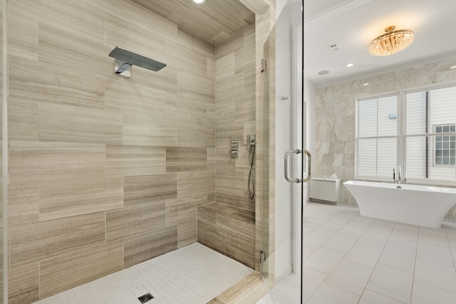 bathroom featuring plus walk in shower, tile patterned flooring, and tile walls