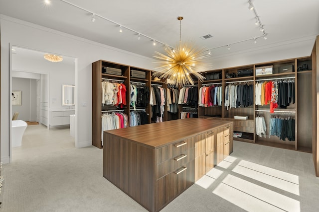 walk in closet with a chandelier and light colored carpet