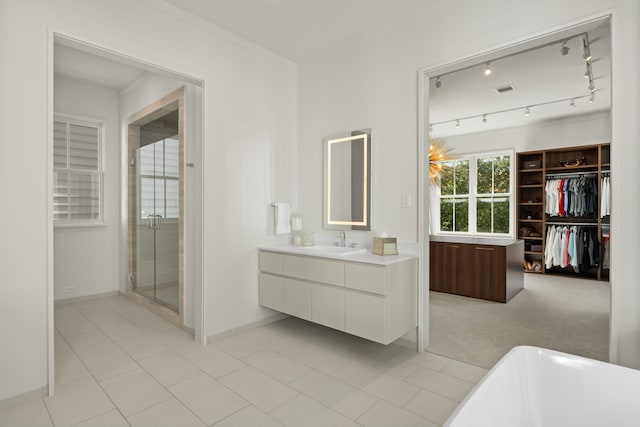 bathroom with tile patterned floors, crown molding, vanity, and shower with separate bathtub