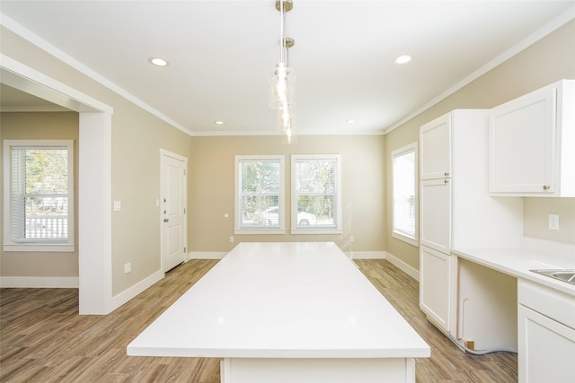 6609 Greenhurst St, Houston, TX 77091 - kitchen with light wood-type flooring, healthy amount of natural light, light countertops, white cabinetry, and ornamental molding