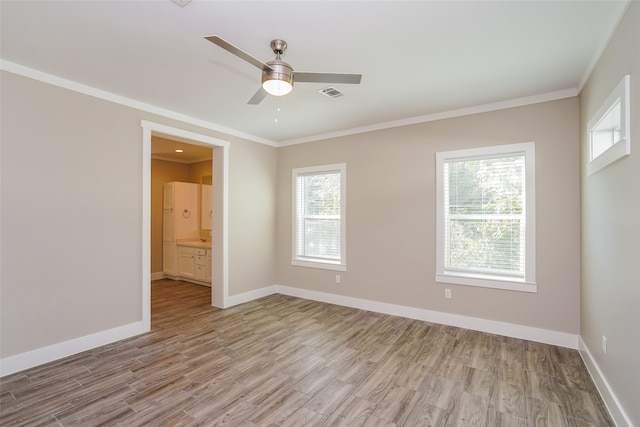 spare room featuring light hardwood / wood-style flooring, plenty of natural light, ornamental molding, and ceiling fan