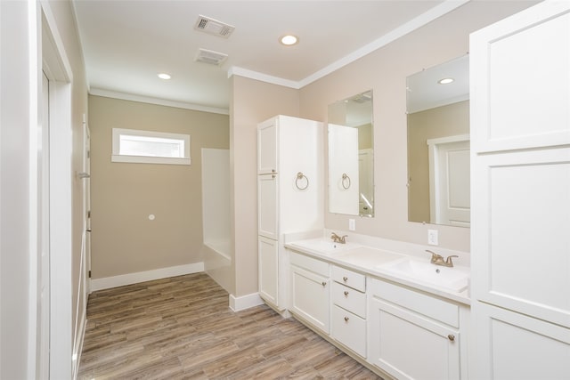 bathroom featuring wood-type flooring, vanity, and ornamental molding