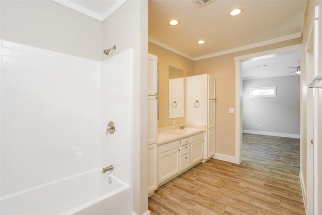 bathroom with ceiling fan, vanity, crown molding, wood-type flooring, and shower / bathing tub combination