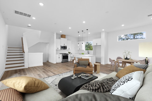 4124 Bucks St, Houston, TX 77020 - living room featuring stairs, light wood finished floors, and recessed lighting