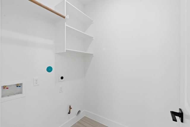 clothes washing area featuring hardwood / wood-style floors, hookup for an electric dryer, gas dryer hookup, and hookup for a washing machine