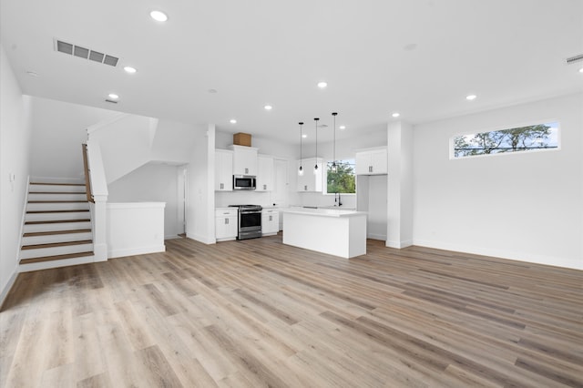 unfurnished living room with light wood-type flooring and sink